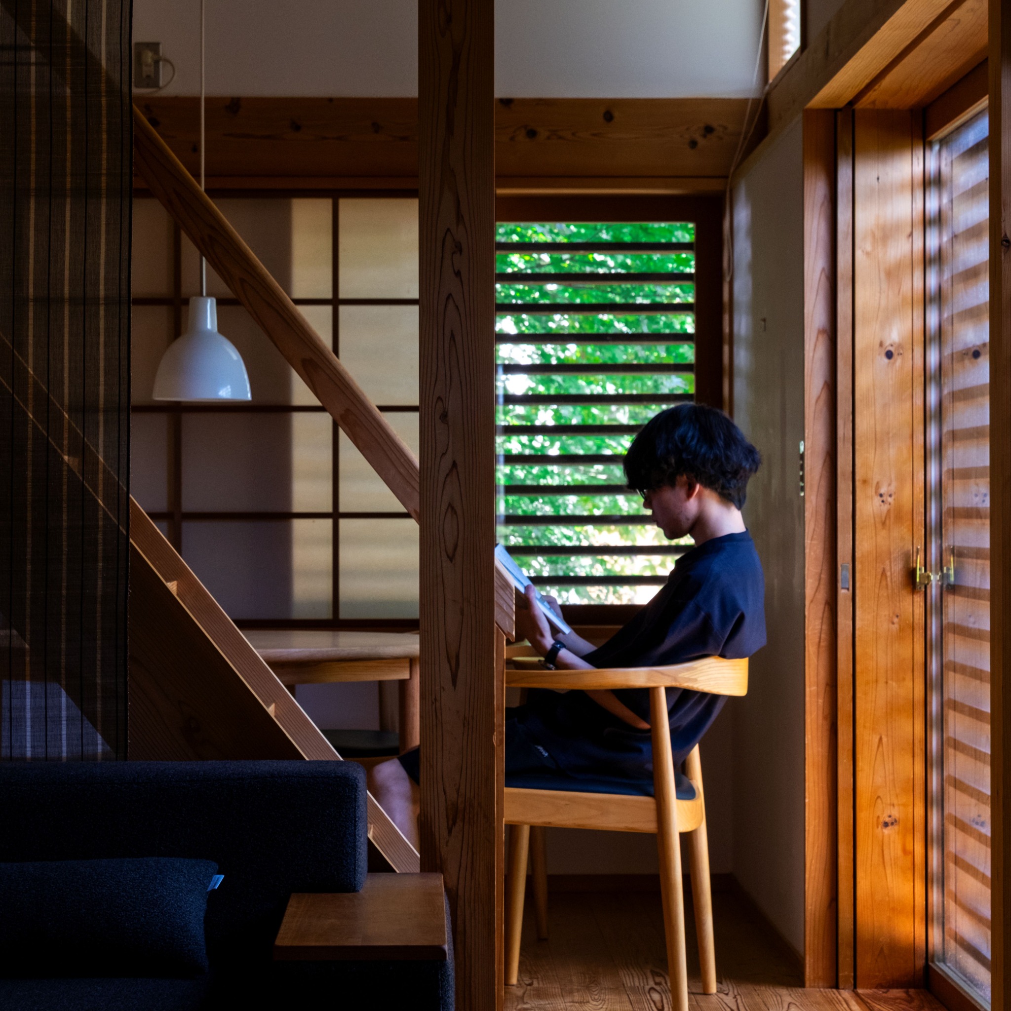木の空間で本を読む鈴木健成